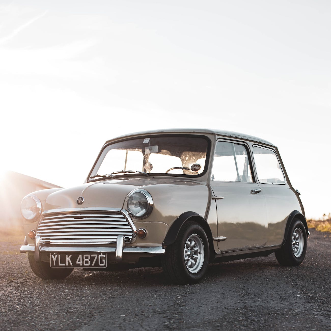 a mini classic car on the unpaved road